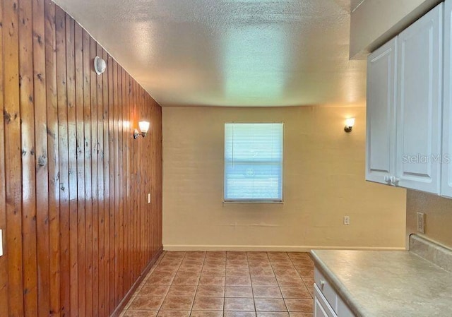 316AND318 Bay Ave, Cocoa, FL 32922 - kitchen featuring wood walls, a textured ceiling, white cabinetry, and light countertops