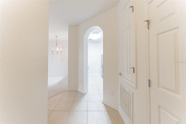 1355 Venezia Ct Unit 201, Davenport, FL 33896 - corridor with arched walkways, a chandelier, light tile patterned flooring, and light colored carpet