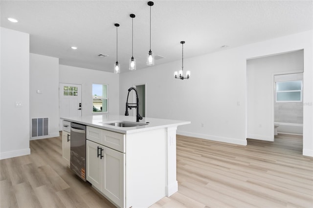 9312 N Akola Way, Citrus Springs, FL 34434 - kitchen featuring light wood-style flooring, stainless steel dishwasher, light countertops, pendant lighting, and white cabinetry