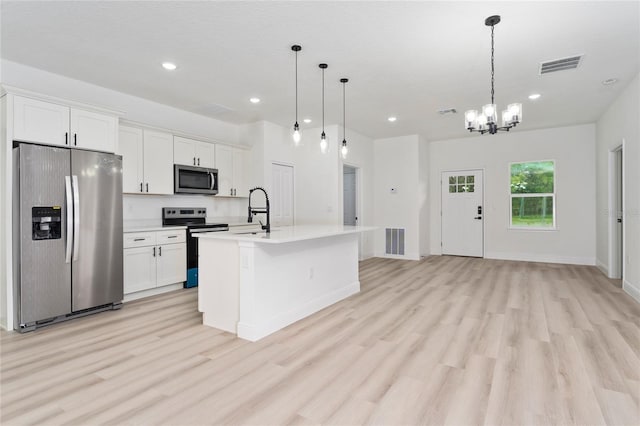 9312 N Akola Way, Citrus Springs, FL 34434 - kitchen with appliances with stainless steel finishes, light wood-style floors, recessed lighting, light countertops, and a kitchen island with sink
