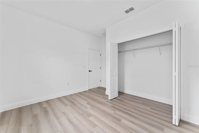 9312 N Akola Way, Citrus Springs, FL 34434 - unfurnished bedroom featuring light wood finished floors and a closet