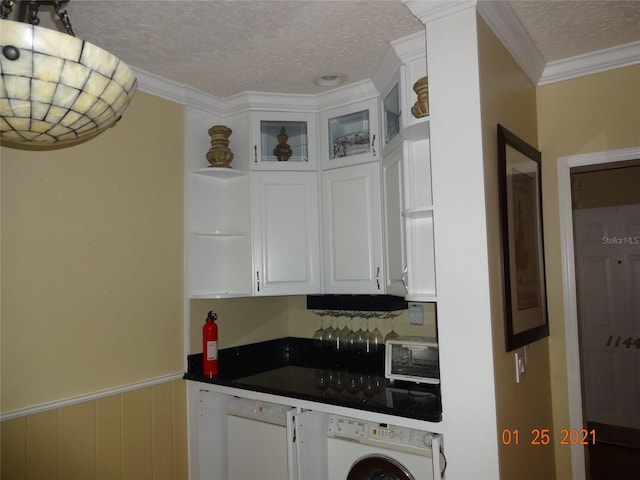 1144 Delaney Ave Unit 1144, Orlando, FL 32806 - kitchen featuring washer / clothes dryer, a textured ceiling, white cabinets, dark countertops, and ornamental molding