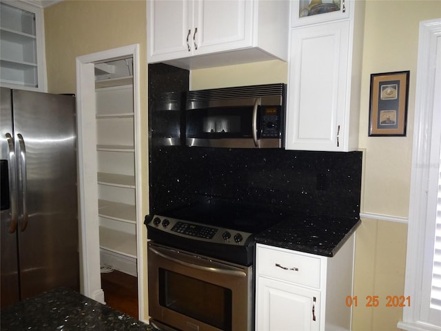 1144 Delaney Ave Unit 1144, Orlando, FL 32806 - kitchen featuring stainless steel appliances, white cabinets, dark stone countertops, and glass insert cabinets
