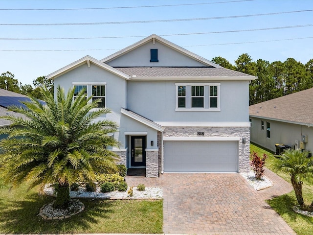 2452 Camden Park Ave, Davenport, FL 33837 - view of front of home with stone siding, stucco siding, decorative driveway, and a garage