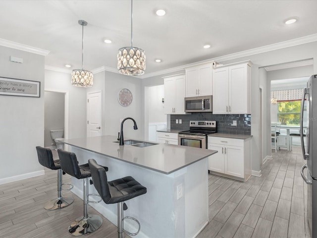 2452 Camden Park Ave, Davenport, FL 33837 - kitchen with stainless steel appliances, a chandelier, light wood-type flooring, a kitchen breakfast bar, and white cabinets