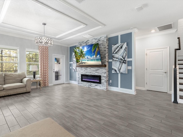 2452 Camden Park Ave, Davenport, FL 33837 - unfurnished living room featuring wood finished floors, a chandelier, a large fireplace, crown molding, and a textured ceiling
