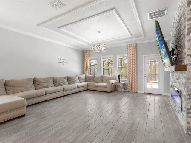 2452 Camden Park Ave, Davenport, FL 33837 - living room featuring a tray ceiling, a fireplace, a chandelier, and wood finished floors