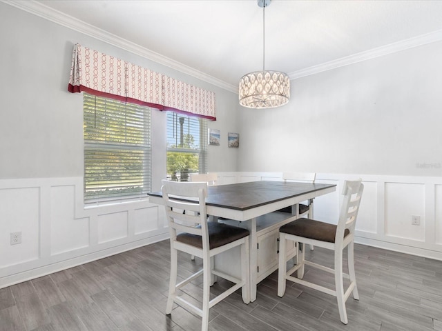 2452 Camden Park Ave, Davenport, FL 33837 - dining area featuring a decorative wall, wainscoting, ornamental molding, wood finished floors, and a chandelier