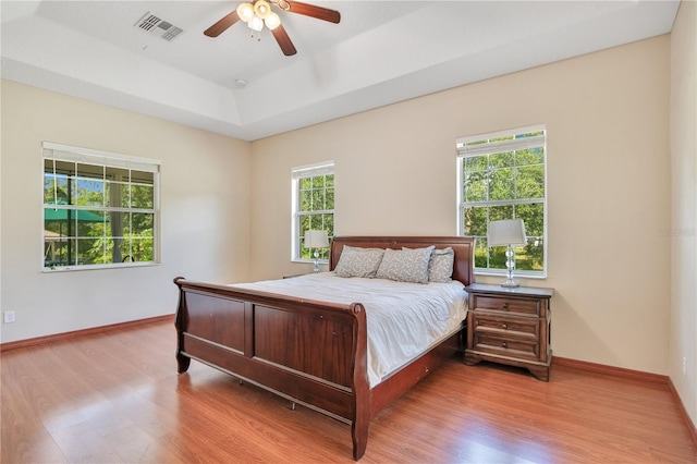 18852 Starry St, Orlando, FL 32833 - bedroom with light wood finished floors, a raised ceiling, and ceiling fan