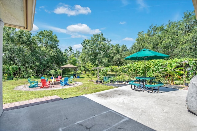 18852 Starry St, Orlando, FL 32833 - view of patio featuring an outdoor fire pit, view of scattered trees, and a gazebo