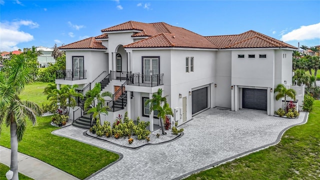 1329 Jumana Loop, Apollo Beach, FL 33572 - mediterranean / spanish house with stairs, decorative driveway, an attached garage, a tile roof, and a front lawn