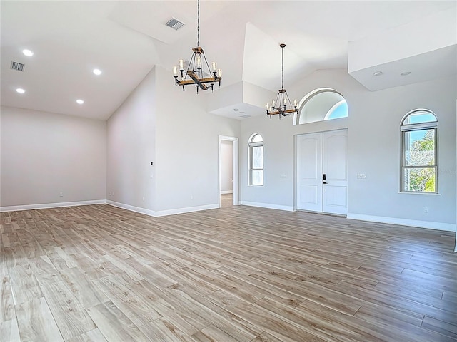 1329 Jumana Loop, Apollo Beach, FL 33572 - unfurnished living room with a chandelier, light wood finished floors, high vaulted ceiling, and recessed lighting
