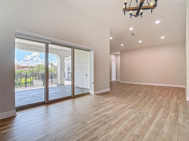 1329 Jumana Loop, Apollo Beach, FL 33572 - empty room featuring a chandelier, light wood-style floors, a high ceiling, and recessed lighting