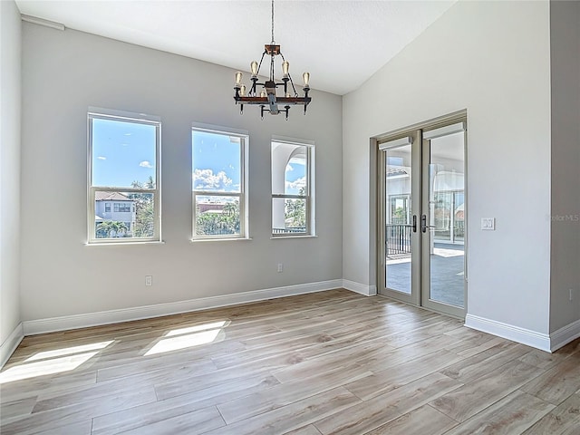 1329 Jumana Loop, Apollo Beach, FL 33572 - unfurnished room featuring french doors, a chandelier, light wood-style flooring, and lofted ceiling