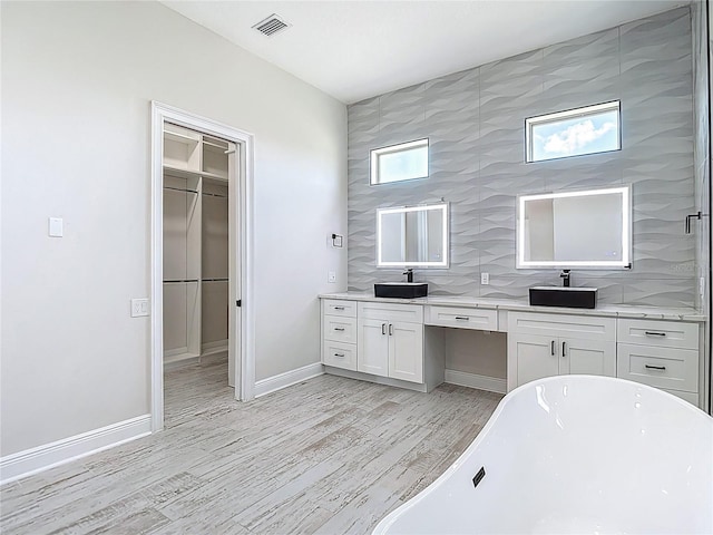 1329 Jumana Loop, Apollo Beach, FL 33572 - full bath with a freestanding bath, double vanity, wood finished floors, and a spacious closet