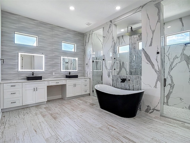 1329 Jumana Loop, Apollo Beach, FL 33572 - full bath with a marble finish shower, double vanity, a freestanding tub, recessed lighting, and wood finished floors