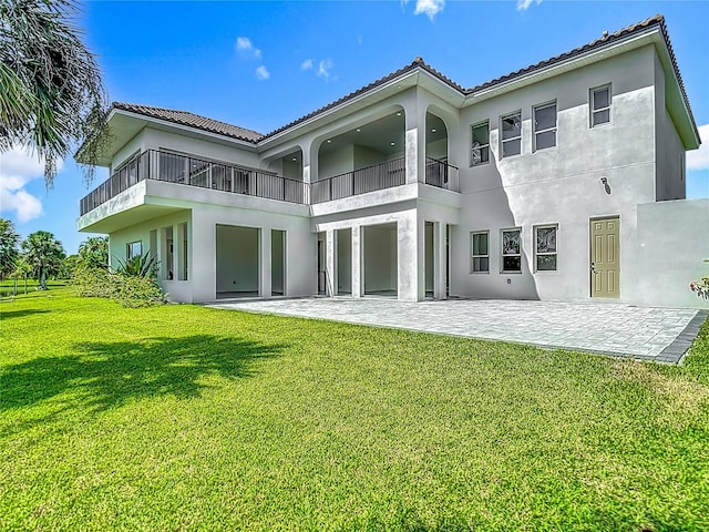 1329 Jumana Loop, Apollo Beach, FL 33572 - back of property featuring a balcony, a patio area, a lawn, stucco siding, and a tile roof