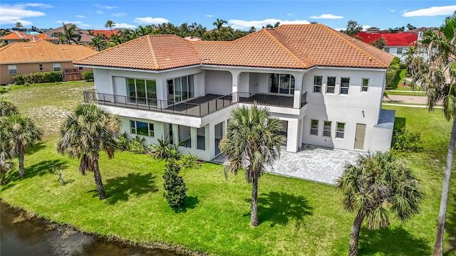 1329 Jumana Loop, Apollo Beach, FL 33572 - back of house featuring a balcony, stucco siding, a lawn, and a tiled roof