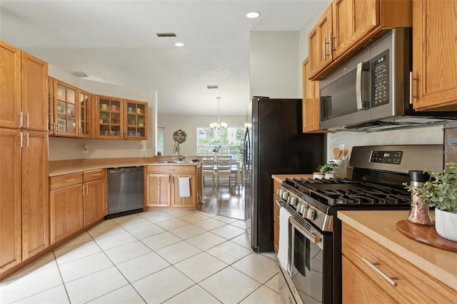 2212 Clementine Trl, Clermont, FL 34714 - kitchen featuring appliances with stainless steel finishes, light countertops, a peninsula, glass insert cabinets, and recessed lighting