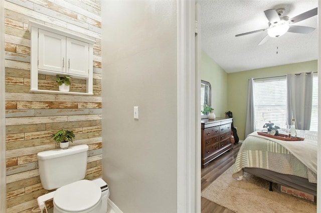 2212 Clementine Trl, Clermont, FL 34714 - bathroom featuring wood walls, wood finished floors, ceiling fan, vaulted ceiling, and a textured ceiling