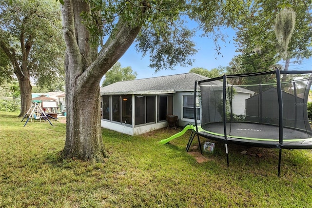 2212 Clementine Trl, Clermont, FL 34714 - back of house with a trampoline, a sunroom, a yard, a playground, and a shingled roof