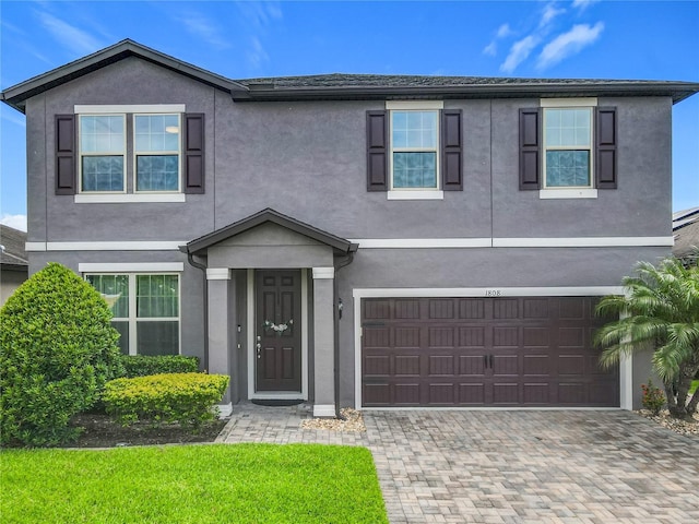 1808 Regal River Cir, Ocoee, FL 34761 - view of front of house with stucco siding, an attached garage, and decorative driveway