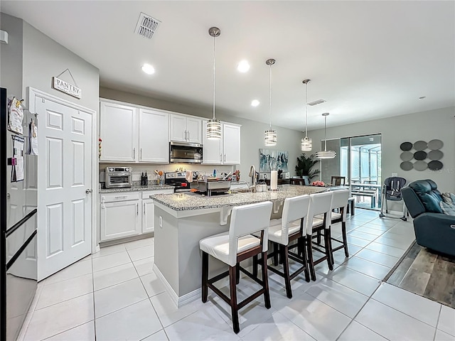 1808 Regal River Cir, Ocoee, FL 34761 - kitchen featuring appliances with stainless steel finishes, a kitchen breakfast bar, white cabinets, and recessed lighting