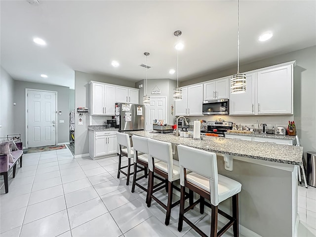 1808 Regal River Cir, Ocoee, FL 34761 - kitchen featuring appliances with stainless steel finishes, recessed lighting, hanging light fixtures, light stone counters, and a kitchen breakfast bar