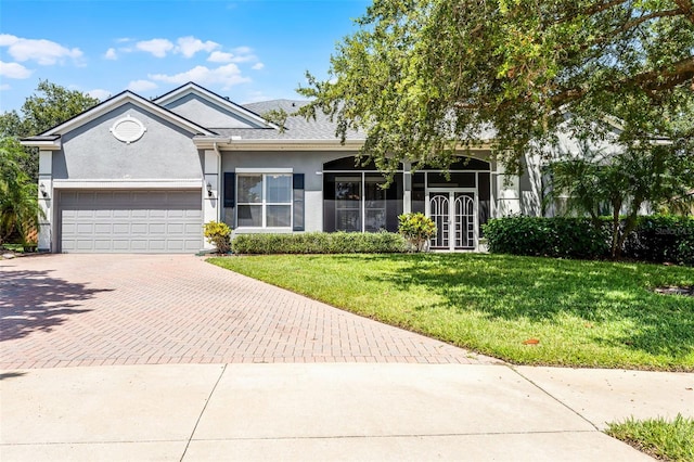 2495 Squaw Crk, Clermont, FL 34711 - ranch-style home featuring decorative driveway, stucco siding, a garage, a front lawn, and french doors