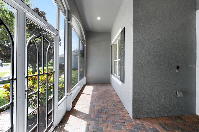 2495 Squaw Crk, Clermont, FL 34711 - unfurnished sunroom featuring a textured wall, brick flooring, healthy amount of natural light, and recessed lighting