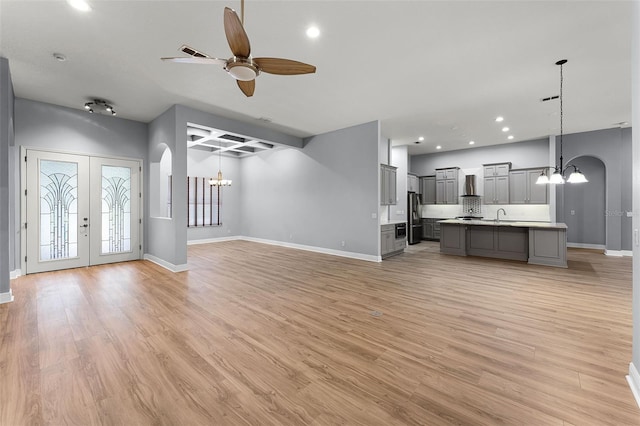 2495 Squaw Crk, Clermont, FL 34711 - unfurnished living room with a chandelier, a ceiling fan, arched walkways, and recessed lighting