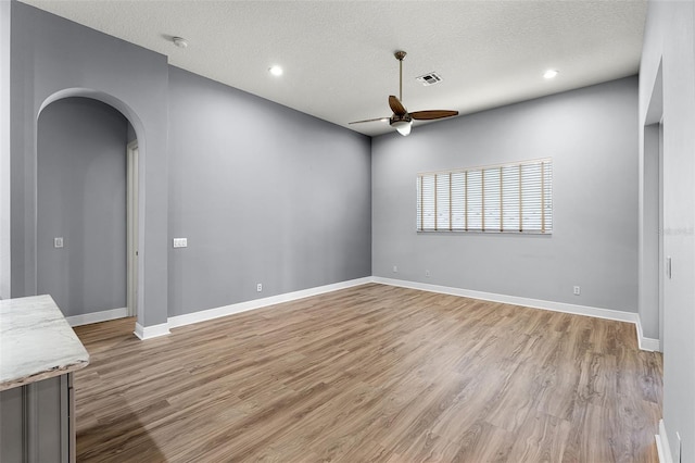 2495 Squaw Crk, Clermont, FL 34711 - spare room with ceiling fan, arched walkways, light wood-style floors, a textured ceiling, and recessed lighting