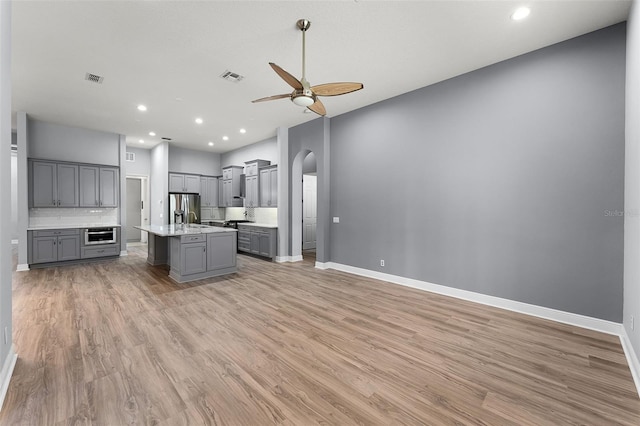 2495 Squaw Crk, Clermont, FL 34711 - kitchen with gray cabinetry, a ceiling fan, arched walkways, light wood-style floors, and recessed lighting