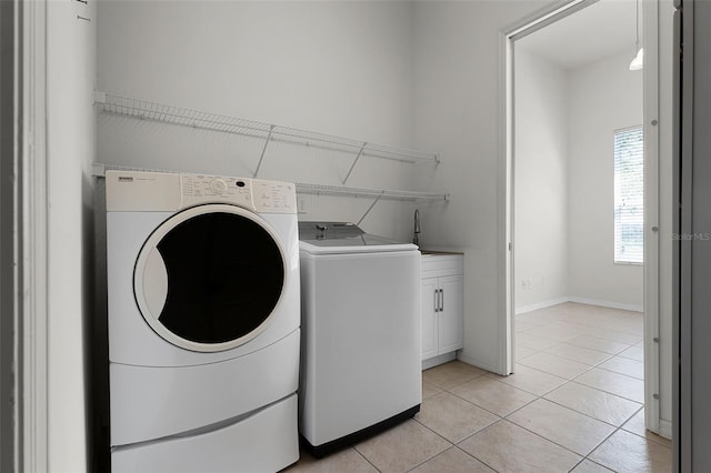 2495 Squaw Crk, Clermont, FL 34711 - washroom featuring washer and clothes dryer, light tile patterned floors, and cabinet space