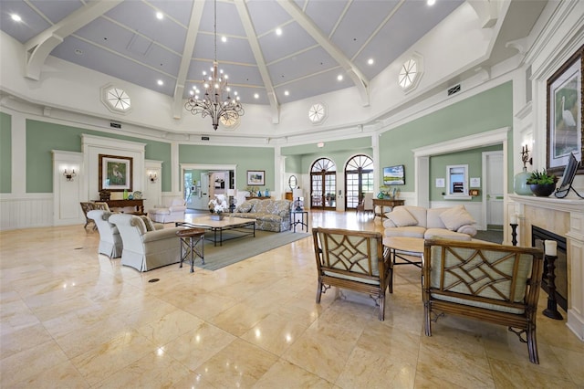 2495 Squaw Crk, Clermont, FL 34711 - living room with a decorative wall, a high ceiling, a premium fireplace, a chandelier, and wainscoting