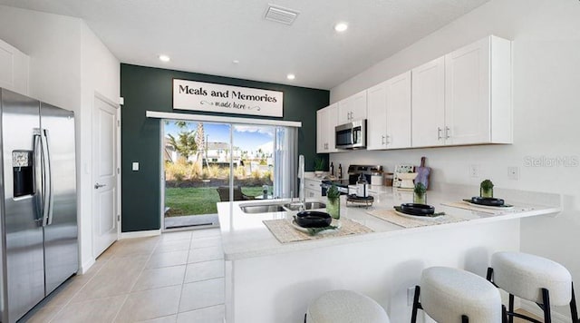 3045 Skyline Loop, Kissimmee, FL 34758 - kitchen with appliances with stainless steel finishes, a peninsula, light countertops, white cabinetry, and recessed lighting