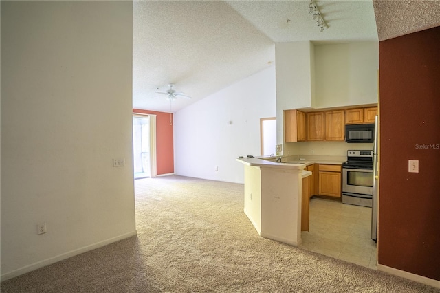 13037 Mulberry Park Dr Unit 5211, Orlando, FL 32821 - kitchen with stainless steel range with electric stovetop, light colored carpet, black microwave, a peninsula, and track lighting