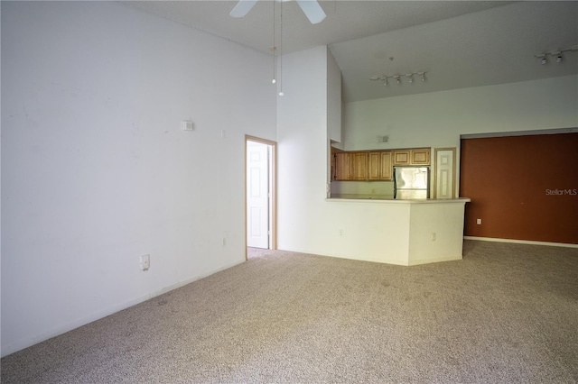 13037 Mulberry Park Dr Unit 5211, Orlando, FL 32821 - unfurnished living room featuring track lighting, carpet flooring, a high ceiling, and ceiling fan