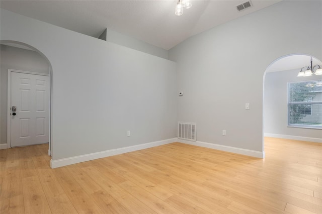988 Vanderbilt Dr, Eustis, FL 32726 - unfurnished room with arched walkways, a chandelier, light wood-type flooring, and high vaulted ceiling