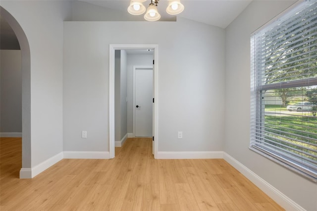 988 Vanderbilt Dr, Eustis, FL 32726 - unfurnished room with arched walkways, healthy amount of natural light, light wood-type flooring, and lofted ceiling