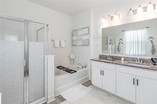 16400 Winding Preserve Cir, Clermont, FL 34714 - bathroom featuring a stall shower, double vanity, a garden tub, and wood finished floors