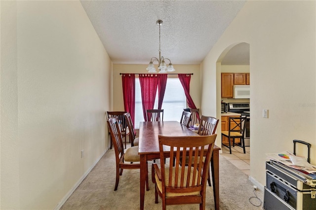 1305 Rebecca Dr, Haines City, FL 33844 - dining space with a textured ceiling, a chandelier, light carpet, and arched walkways