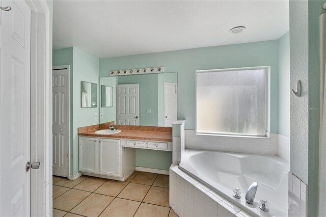 1305 Rebecca Dr, Haines City, FL 33844 - bathroom featuring a garden tub, vanity, and tile patterned flooring