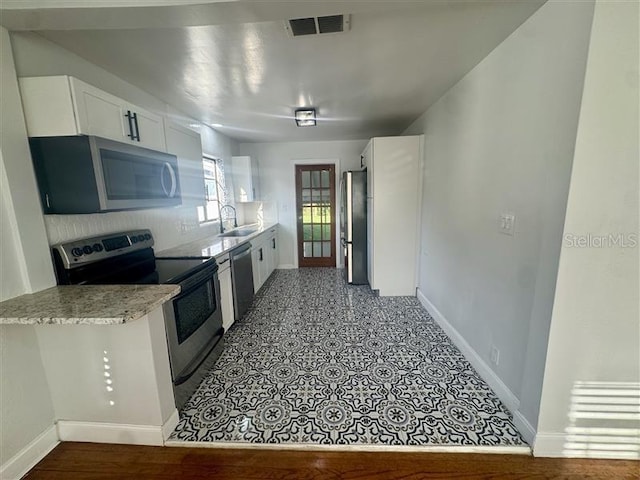 510 S Ingraham Ave, Lakeland, FL 33801 - kitchen featuring stainless steel appliances, white cabinetry, and light stone counters