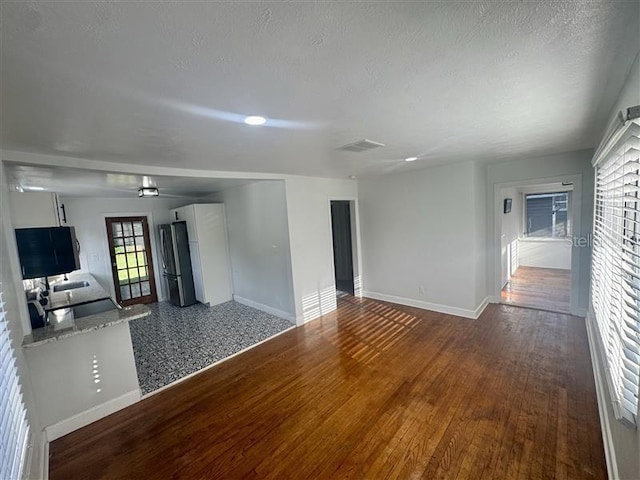 510 S Ingraham Ave, Lakeland, FL 33801 - unfurnished living room featuring baseboards and wood finished floors