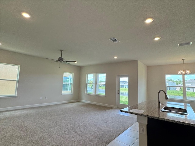 4101 Sagefield Dr, Harmony, FL 34773 - kitchen with light stone counters, a chandelier, a textured ceiling, recessed lighting, and pendant lighting