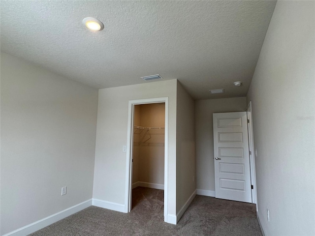 4101 Sagefield Dr, Harmony, FL 34773 - unfurnished bedroom with a walk in closet, carpet, a closet, and a textured ceiling