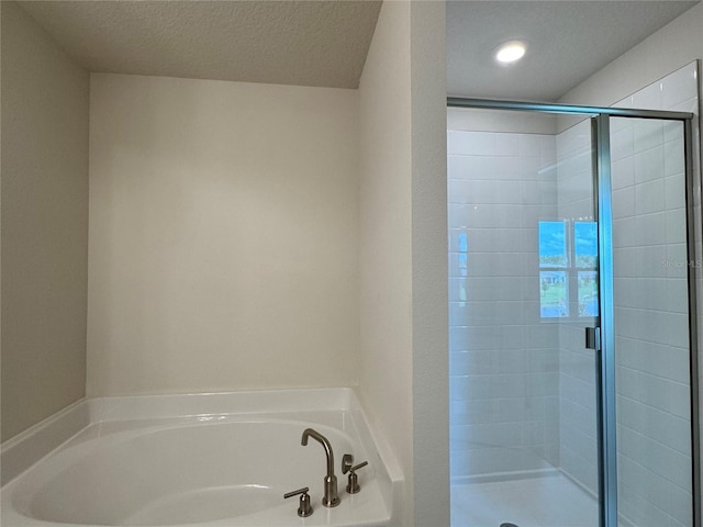 4101 Sagefield Dr, Harmony, FL 34773 - bathroom with a stall shower, a bath, and a textured ceiling