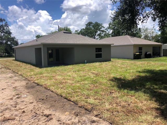 120 Highland Ave, Auburndale, FL 33823 - back of property featuring a yard, stucco siding, and roof with shingles