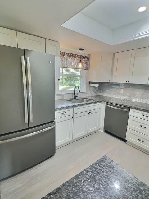 520 Jupiter Blvd NW, Palm Bay, FL 32907 - kitchen with appliances with stainless steel finishes, white cabinets, light wood-style flooring, and decorative backsplash